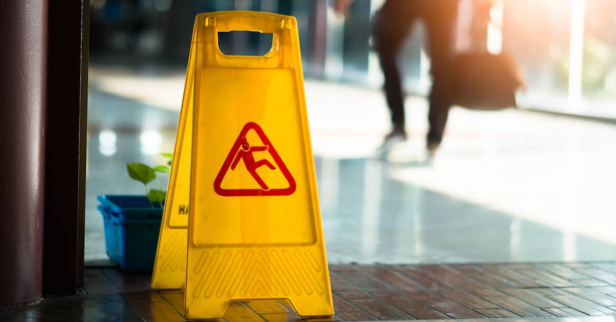 a wet floor sign warns of slip and fall risk | Studinski Law, LLC
