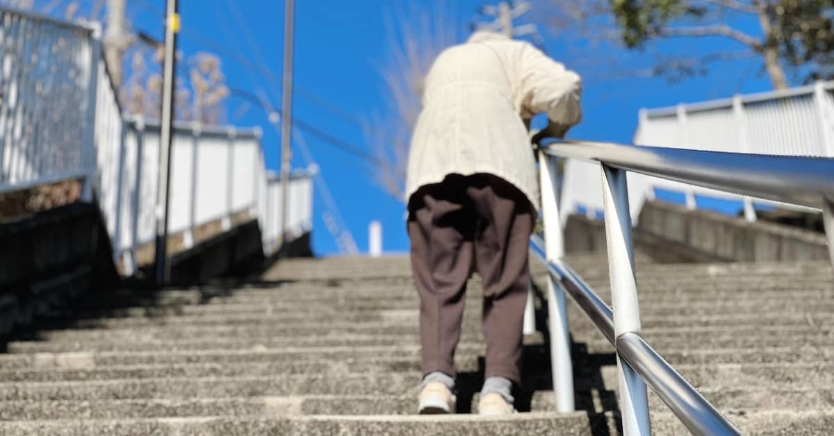 Older person struggling to go up concrete stairs. | Studinski Law